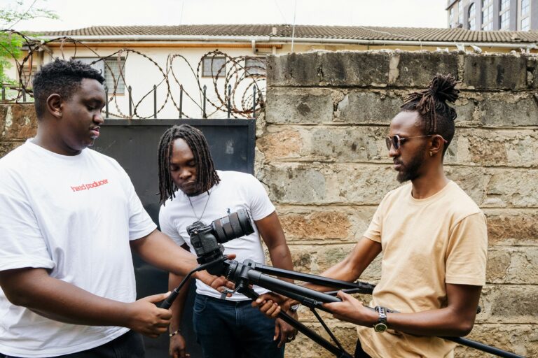 A three-person film crew setting up a camera on a tripod in Nairobi