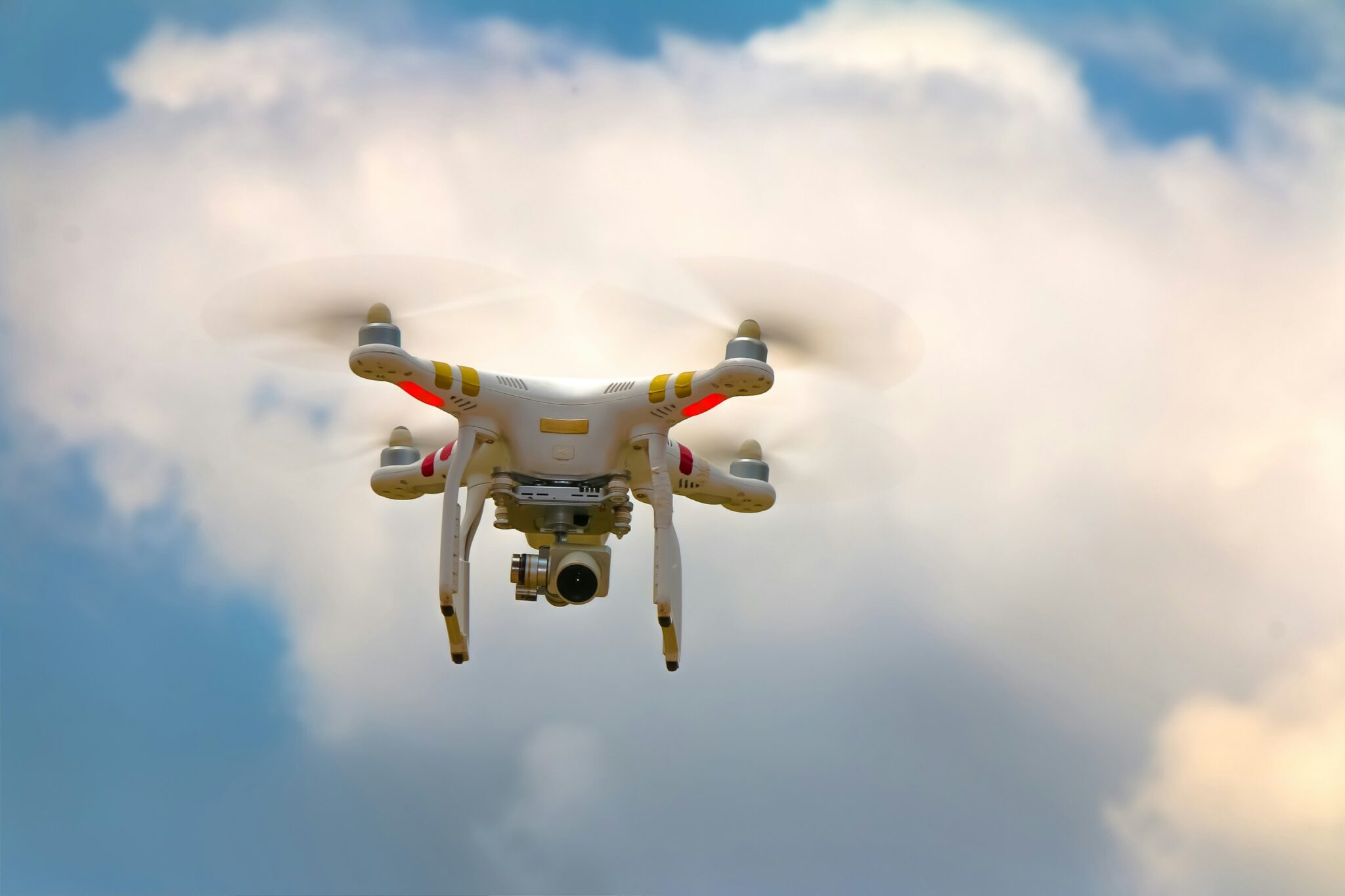 A white camera drone in flight against a cloudy sky in Mukono, Uganda