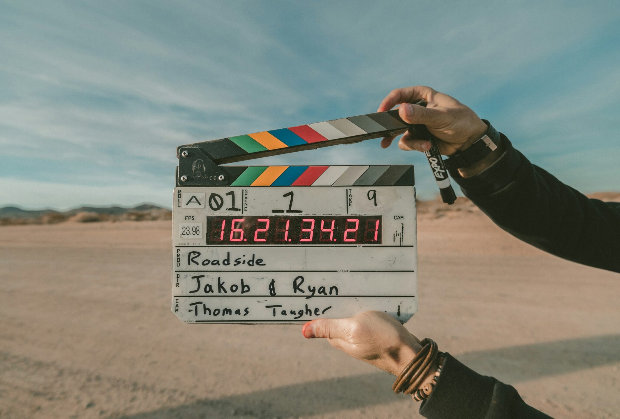 A film clapperboard held up at a roadside shoot