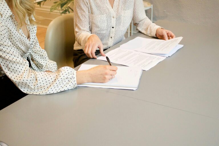 A woman signing a printed form at a table