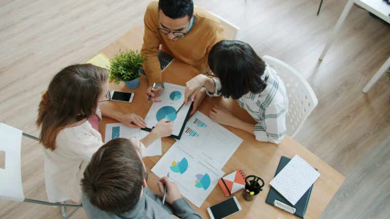 A team working through charts and figures around a table
